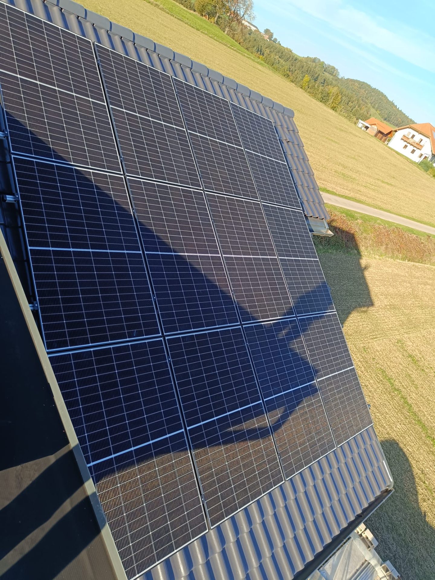Photovoltaikanlage auf einem landwirtschaftlichen Stalldach mit Weitblick ins Feld
